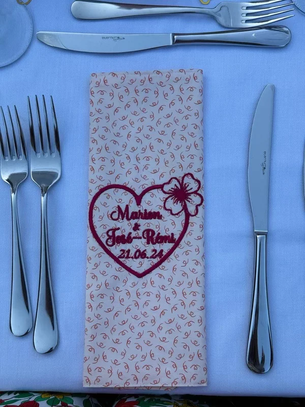 Serviette de table pour un mariage, brodé avec un coeur rouge, ainsi que les prénoms de mariés et la date du mariage
