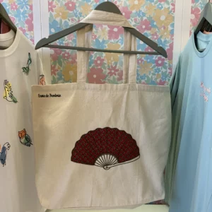 Tote bag couleur naturel avec broderie d'un éventail sur le milieu avec un tissu rouge foncé à l'intéireure