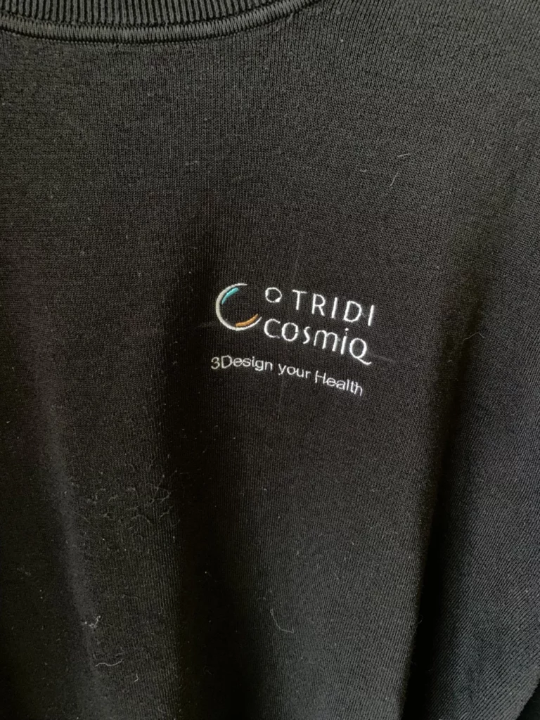 Gros plan d'un logo d'entreprise brodé sur le coeur d'un t-shirt noir