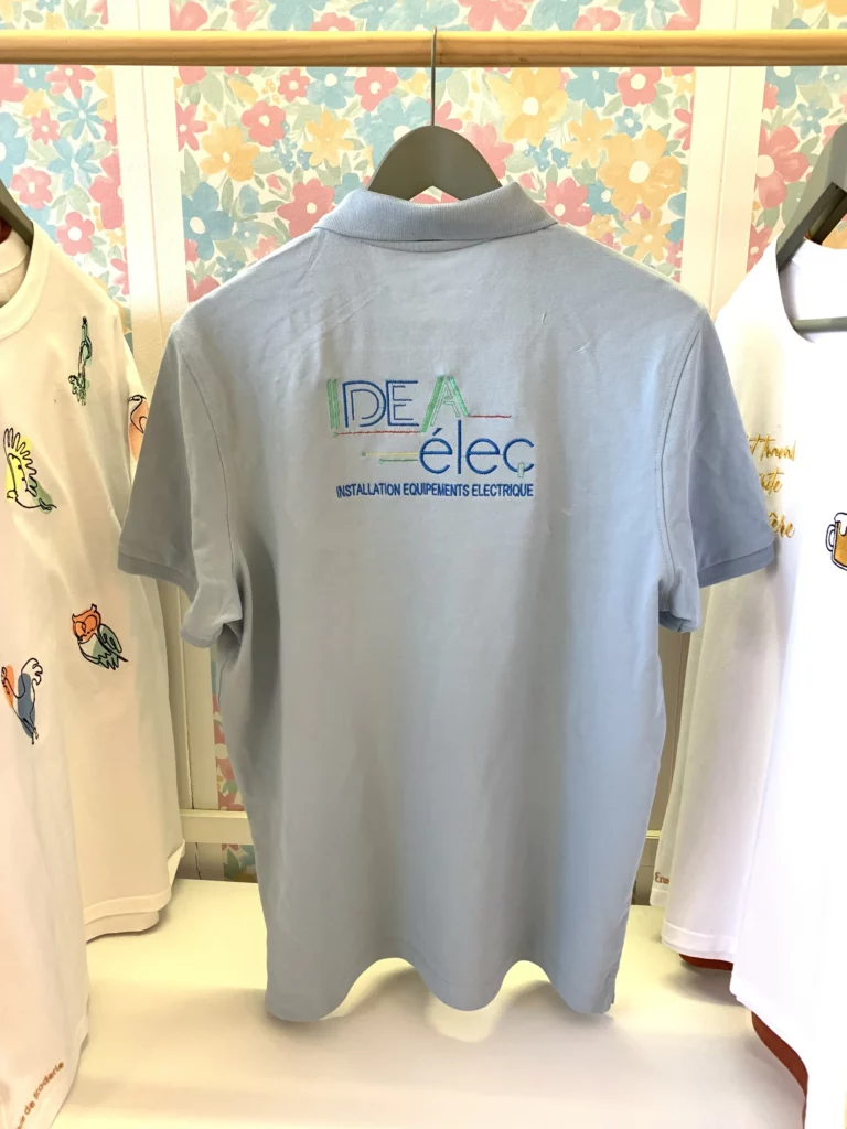 Broderie sur le dos du polo bleu ciel commandé par une entreprise qui veut son logo brodé