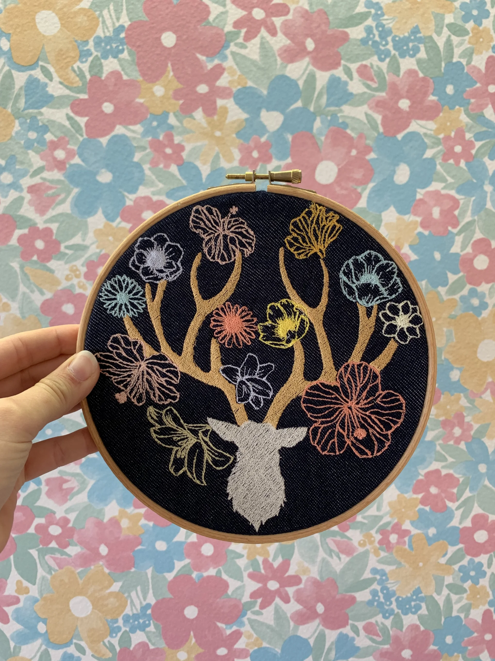 Décoration intérieure textile brodé représentant une tête de cerf entouré de plusieurs fleurs brodés