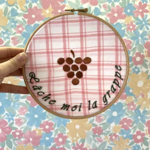 Décoration intérieure en pièce unique, avec une broderie d'une grappe de raisin avec la citation "Lâche moi la grappe"