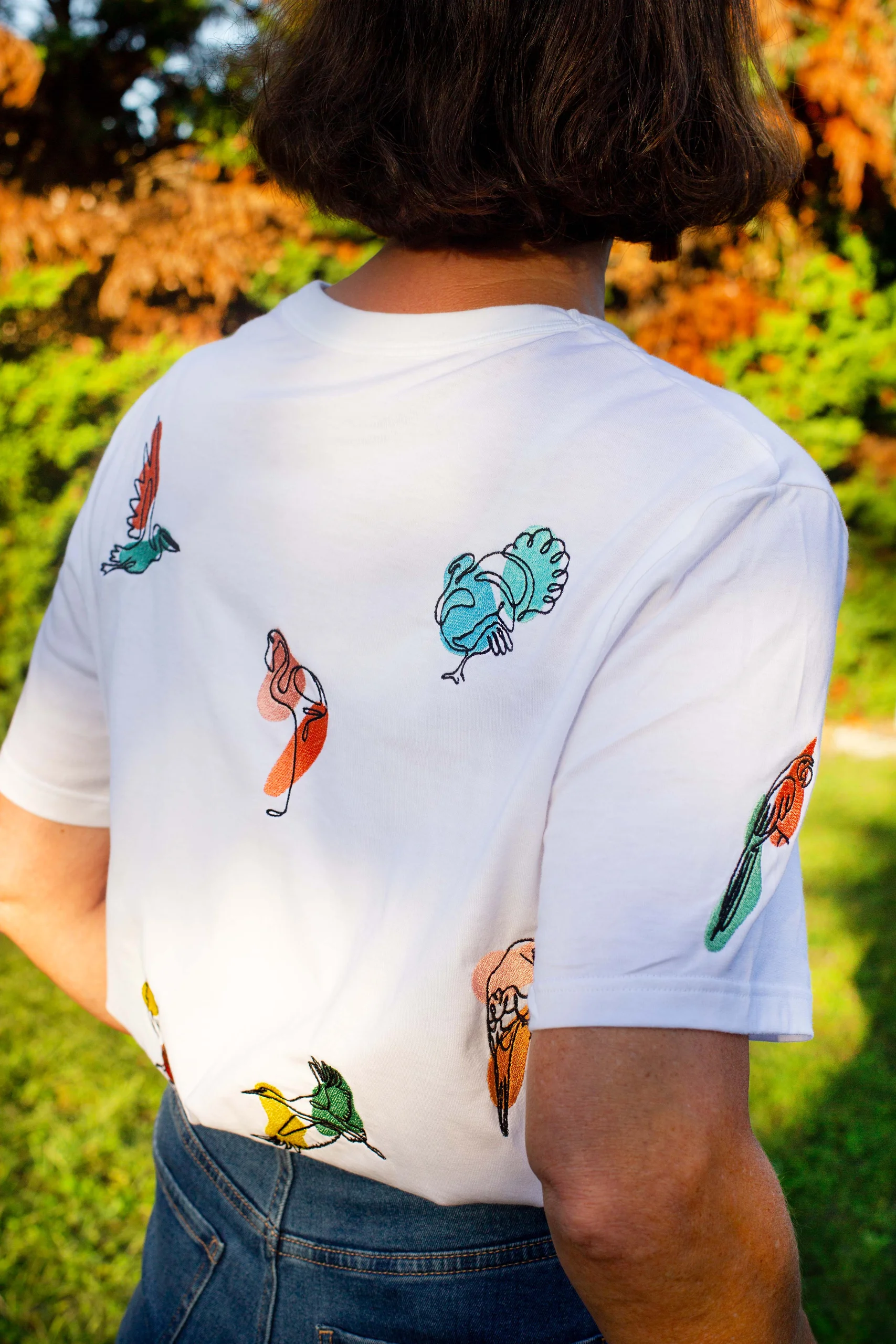Vue de dos du t-shirt brodés avec des oiseaux ainsi que des tâches de couleurs brodés